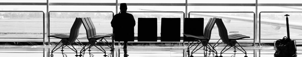 Lone traveler silhouette at an airport gate at night
