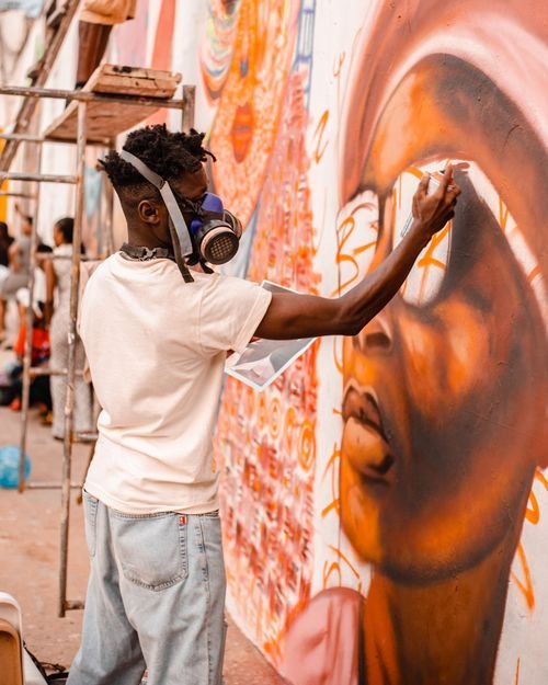 Artist painting a colorful mural in Accra