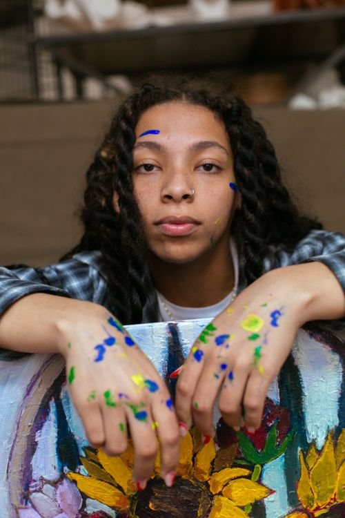 Artist's hands covered in colorful paint