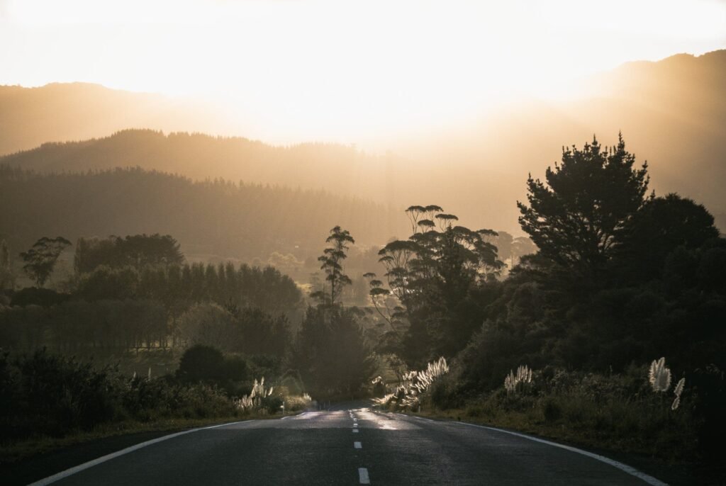 Open road stretching toward a bright sunrise