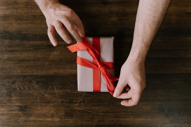 Hands unwrapping a wrapped gift box