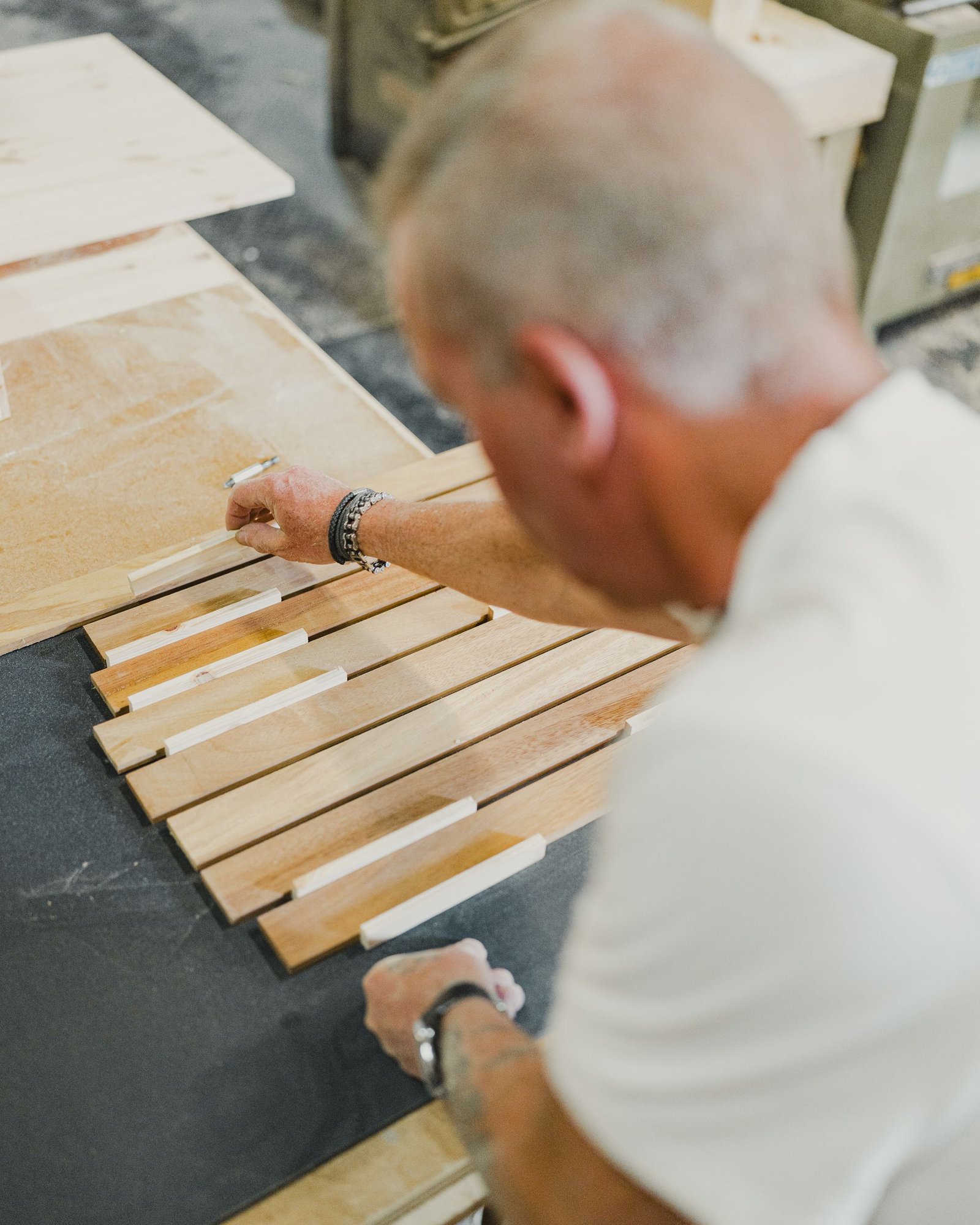 Craftsman aligning wooden slats on a wood project in a workshop — Photo by shoreline vehicles on Pexels